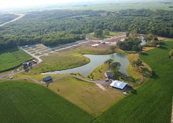 Aerial drone view of Buena Vista Farms campground in Chapin Illinois showing main building, pond, and rolling fields