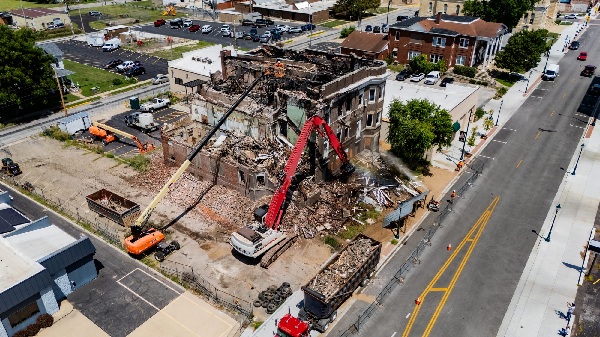 Aerial drone photo of the Cherry Apartments demolition at 342 W State Street Jacksonville IL, high-reach excavator tearing into the fire-damaged brick building