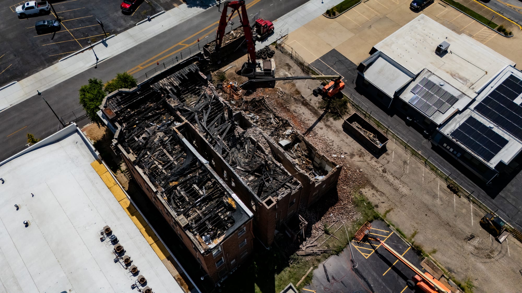 Top-down aerial view of fire-charred roof joists and debris inside the Cherry Apartments during demolition in Jacksonville IL