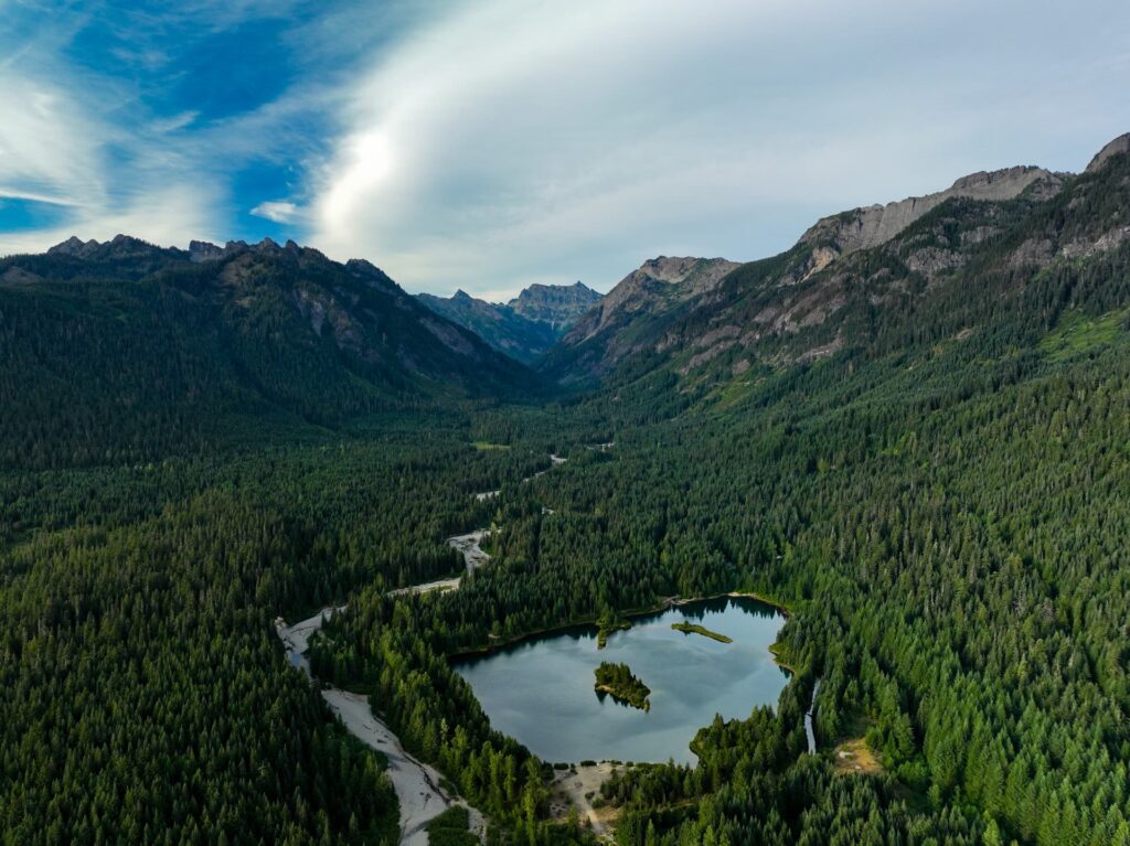 Aerial view of Gold Creek Pond and Gold Creek Valley near Snoqualmie Pass, Washington, with the Alpine Lakes Wilderness peaks behind