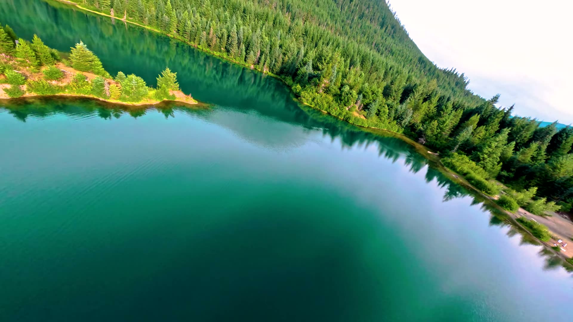 Emerald green water and the small island at Gold Creek Pond from the air