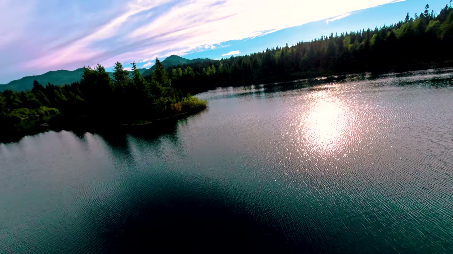 The turquoise glacial water of Gold Creek Pond seen from a low-flying drone