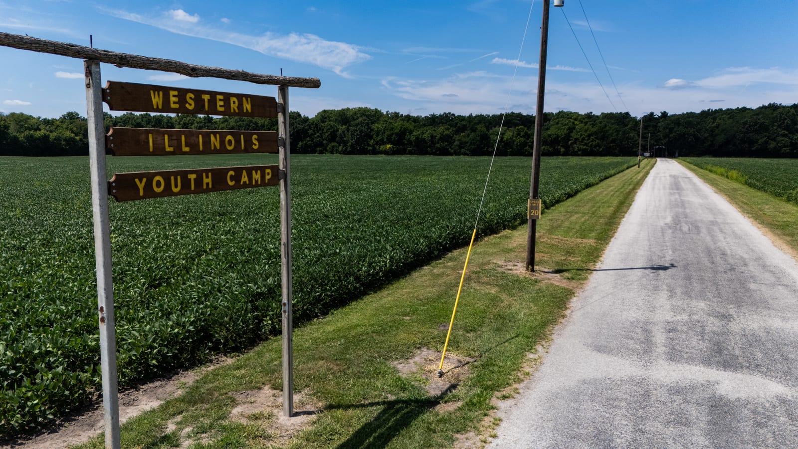 Wooden Western Illinois Youth Camp entrance sign on 4-H Club Lane surrounded by farm fields south of Jacksonville Illinois