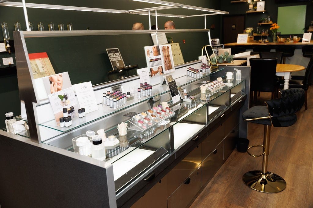 Lit glass display cases of clean makeup and skincare products at Cheryl Kelly & Co. in downtown Jacksonville Illinois