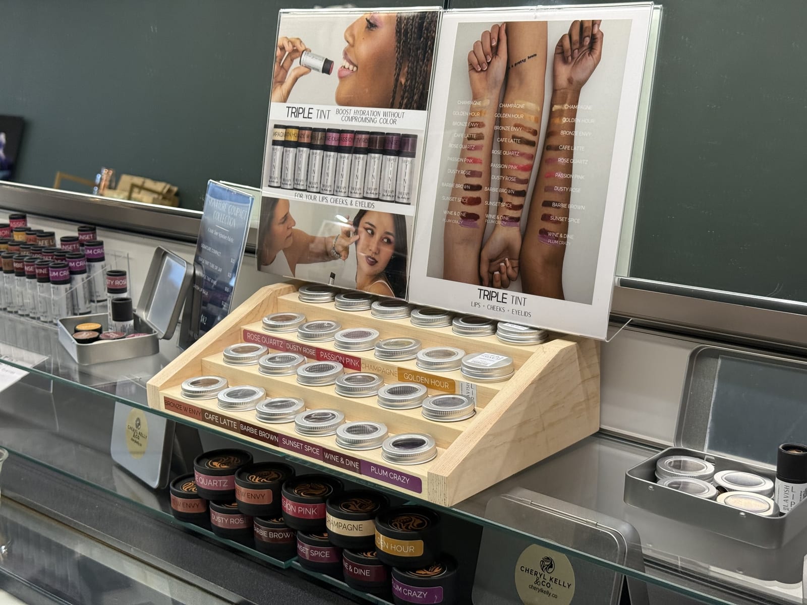 Triple Tint lip, cheek and eyelid tint shades arranged on a wooden display at Cheryl Kelly & Co. in Jacksonville IL